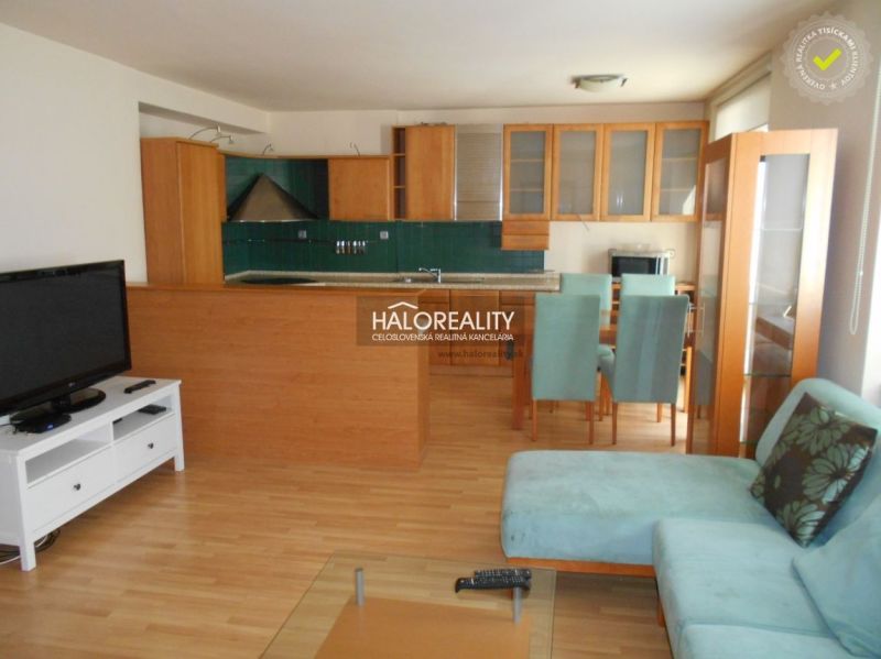 Living room with kitchen in a 3-room apartment with a wooden decor floor.