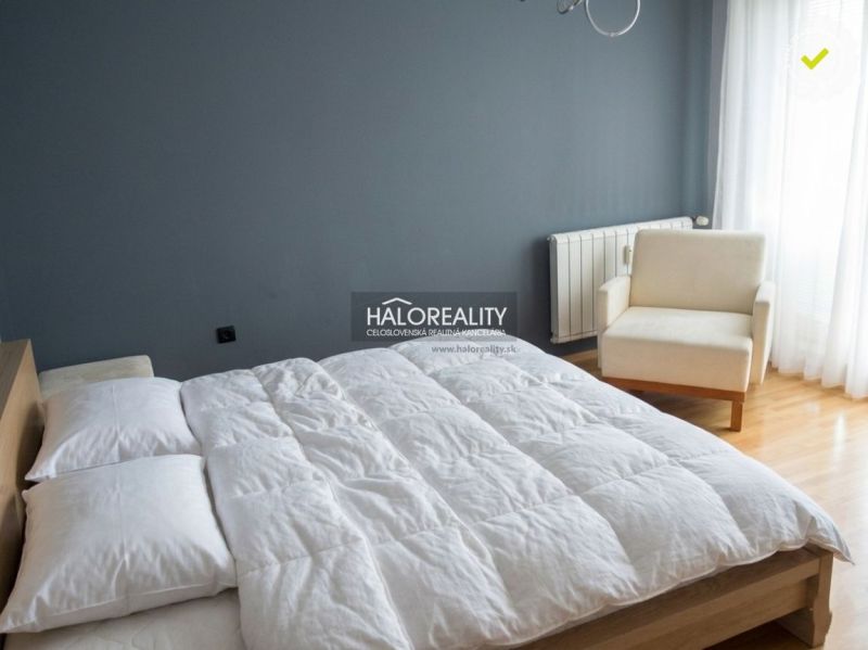 A bedroom in a 3-room apartment with a large bed and an armchair.