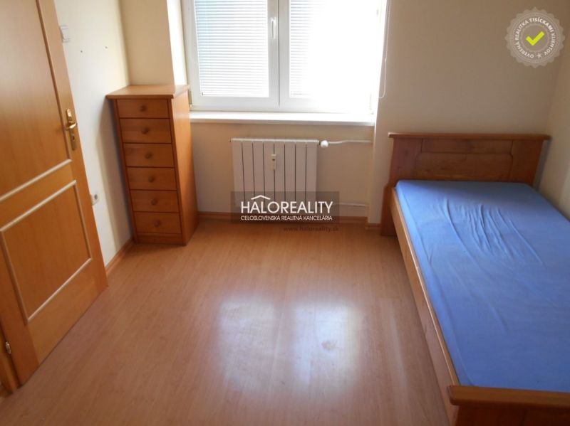 A room in a 3-room apartment with a bed, a dresser, and a floor with a wooden decor.