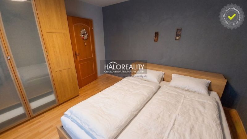 Bedroom in a 3-room apartment with wood-patterned flooring and a large bed.