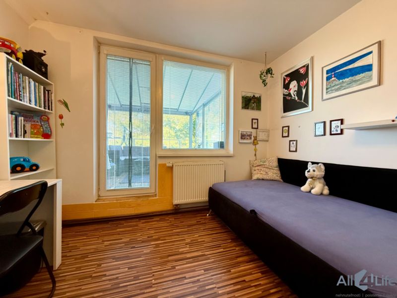 Children's room with a sofa, table, and floor with wood decor in a 3-room apartment.