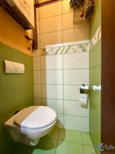 Bathroom in a 3-room apartment with a wall-mounted toilet and light tiles.