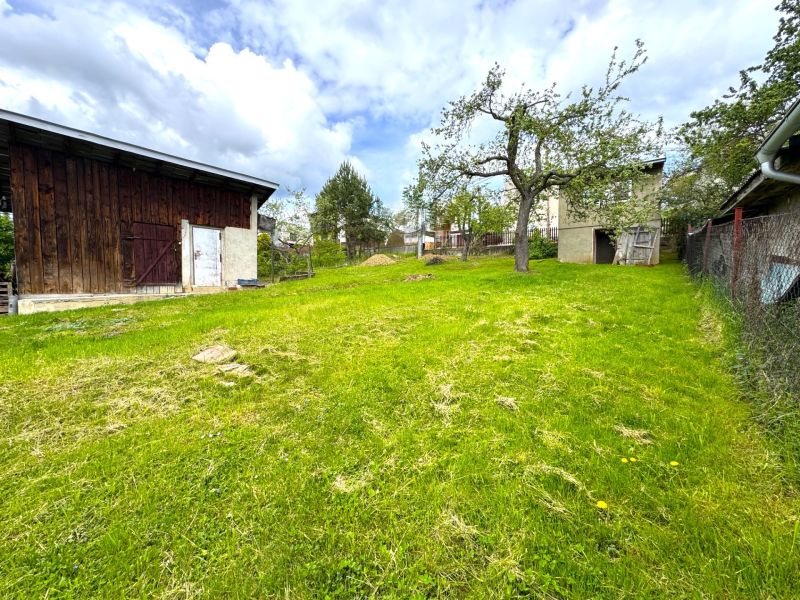 A garden plot for living in Lipany with a wooden shed and a grassy area.