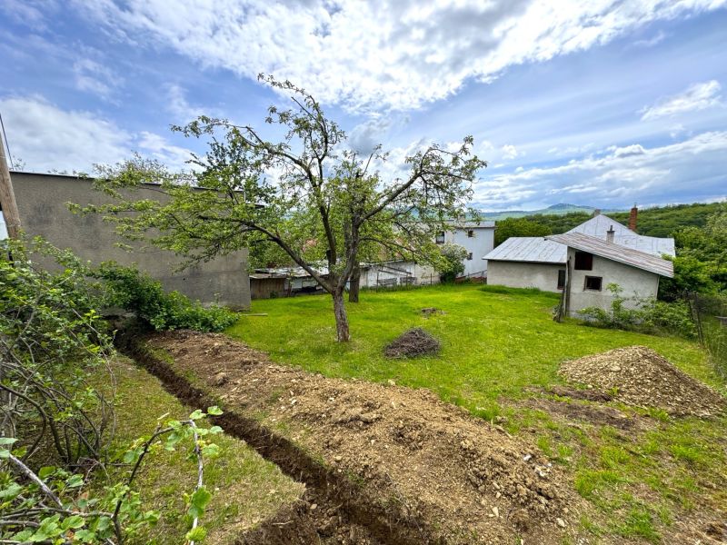 Land in Lipany suitable for living with fruit trees and a farm building.