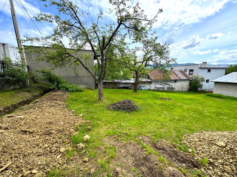 Plots - housing in Lipany with trees and lawn surrounded by buildings and sky.