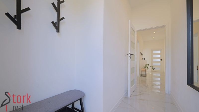 A hallway in a family house with a coat rack, a mirror, and a spacious passage.