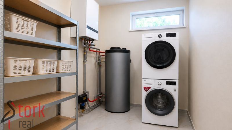 Laundry room in a family house with appliances, a boiler, a shelf, and laundry baskets.