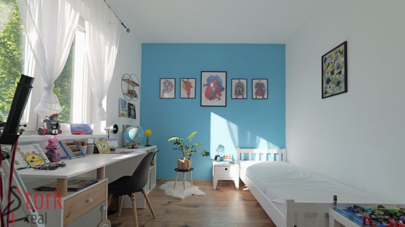 Children's room in a family house with white furniture and a wooden decor floor.
