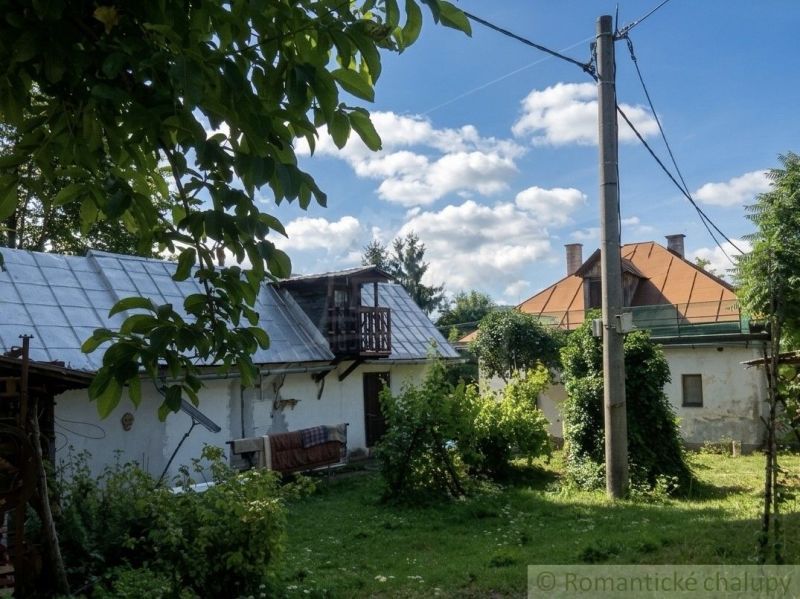 A family house in Štiavnické Bane with a spacious garden and a blue sky full of clouds.