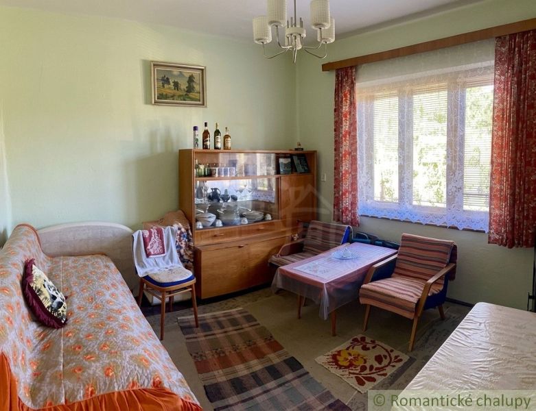 Living room in a family house with vintage furniture and a large window with lace curtains.