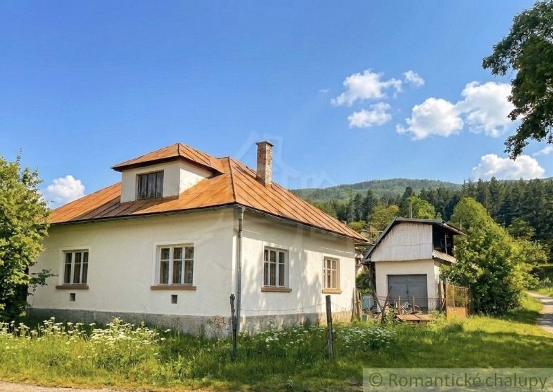 A family house in Štiavnické Bane surrounded by nature and a blue sky.