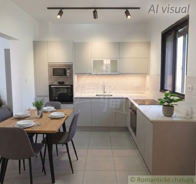 A kitchen in a family house with simple furniture and light gray cabinets.