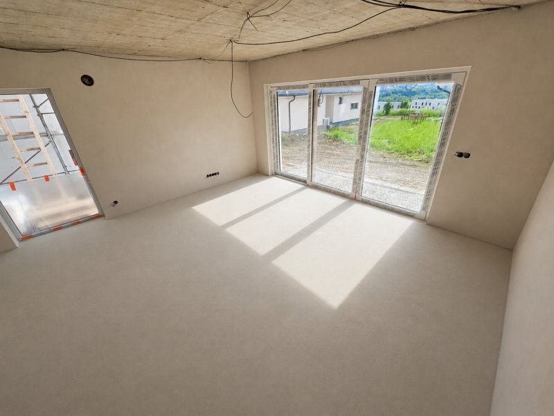 A bright room with large windows and an unfinished ceiling in a 5 or more room apartment.