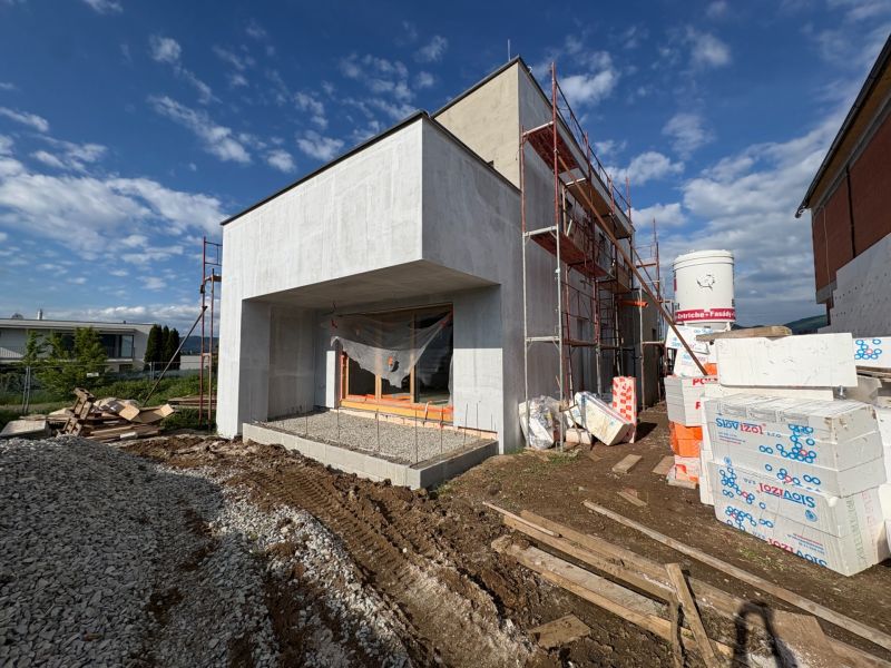 A family house under construction in Prešov with an unfinished facade and building materials around.