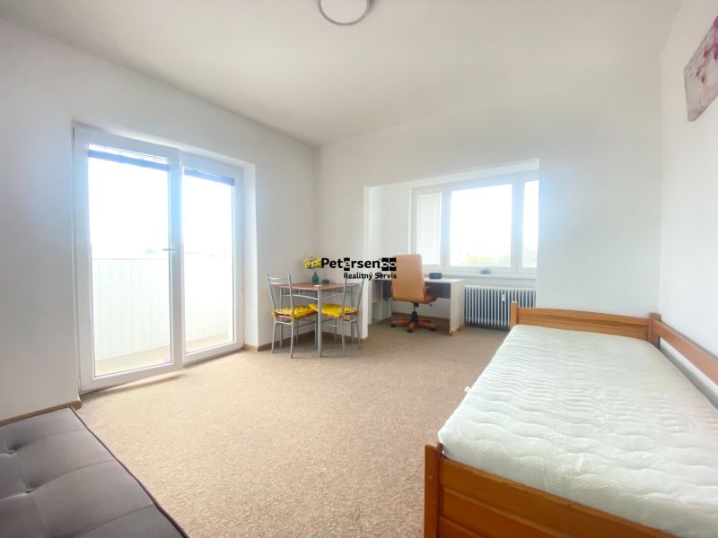 A simple interior of a 3-room apartment with a sofa, table, and bed.