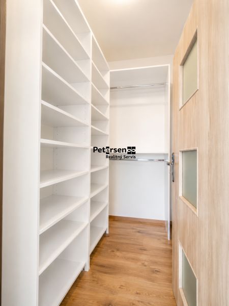 A hallway with built-in shelves and a floor with a wooden decor in a 3-room apartment.