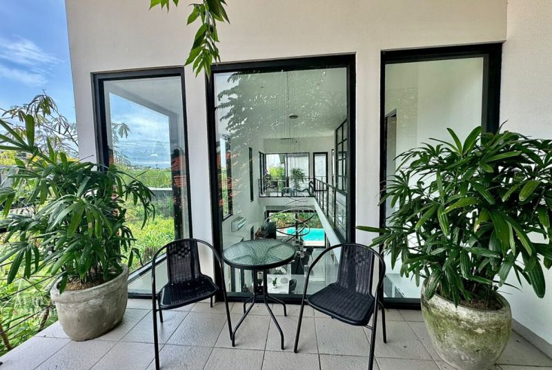 Balcony of a Villa in Bali with a view, plants, and garden furniture.