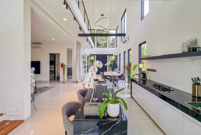 The interior of the villa with a spacious kitchen and dining area, decorated with plants and flowers.