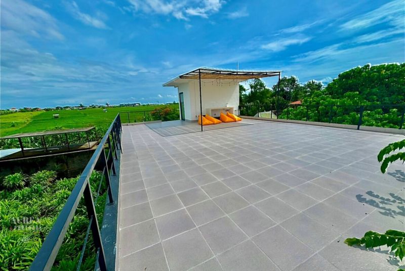 Spacious terrace of the Villa in Bali with a view of the green rice fields.
