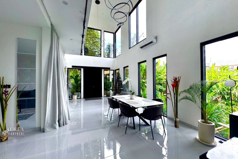 Spacious bright interior of a villa with large windows and modern furniture.