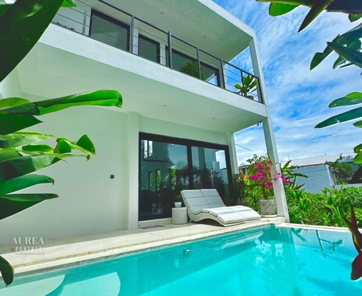 Villa in Bali with a pool and a sunbed, surrounded by exotic greenery.