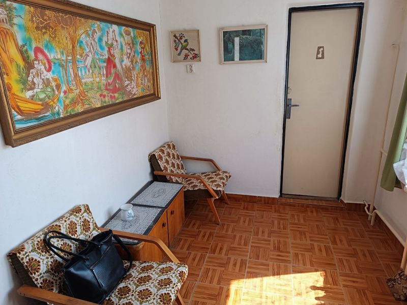 Interior with armchairs, carpet decor, and colorful paintings in a family house.