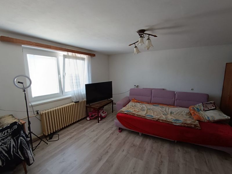 A living room in a family house with a sofa and a wooden decor floor.