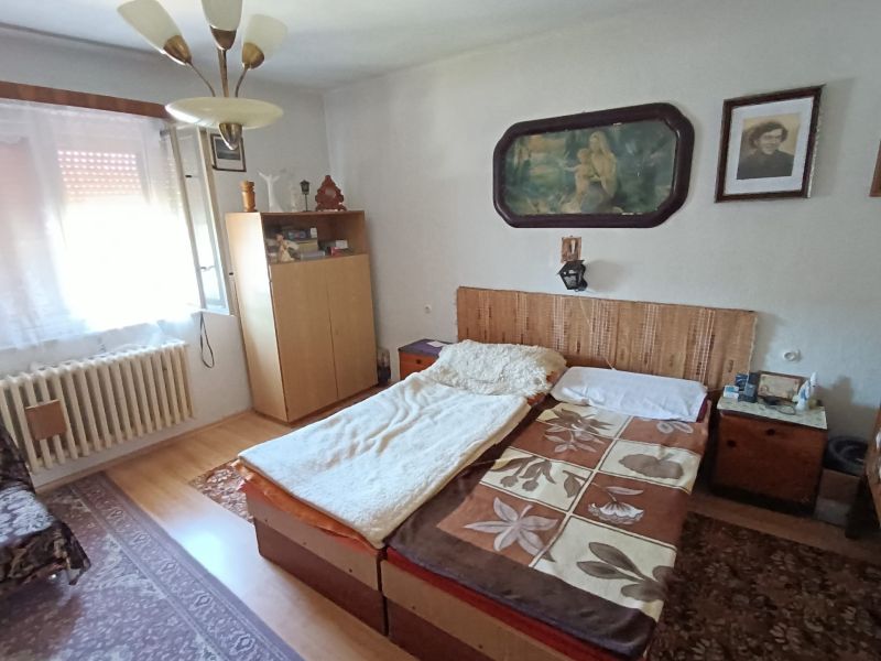 A bedroom in a family house with a drawer bed and wall decorations.