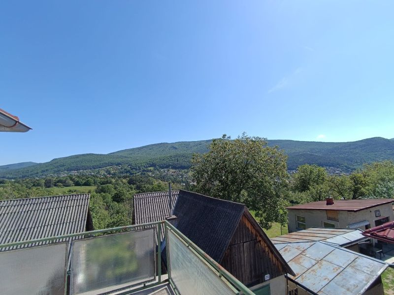 A view from a family house in Nová Baňa of rooftops and wooded hills.