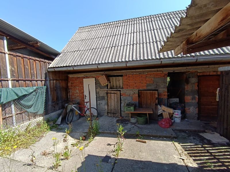 In the yard of a family house in Nová Baňa, there is a bicycle and a shed with a metal roof.