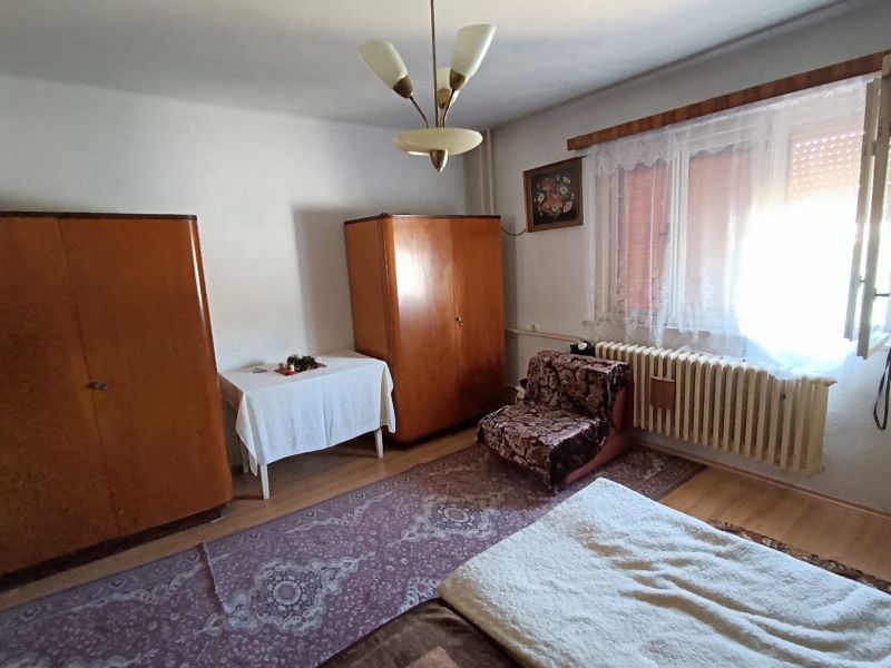 A room in a family house with carpets, older furniture, and a floor with a wooden decor.