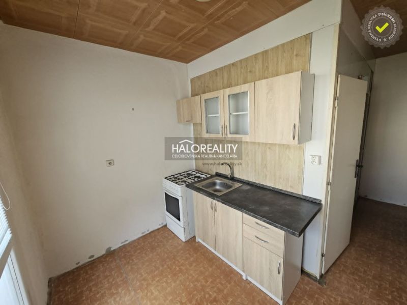 Kitchen corner with a gas stove in a studio apartment and a floor with a wooden decor.