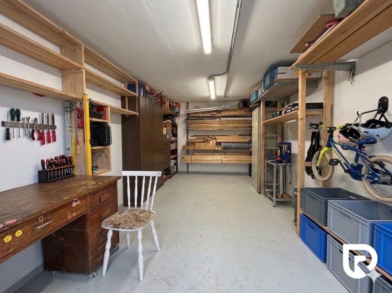 Workshop with a table, shelves, and a bicycle in a 3-room apartment.