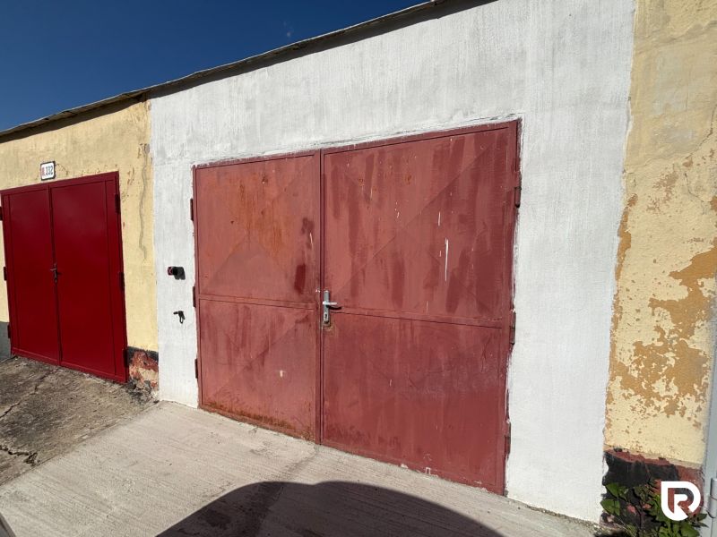 Garages on Vladimíra Roya in Trenčín with red doors and a light facade.