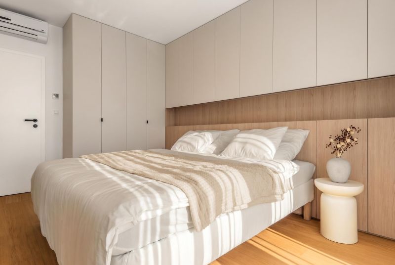 A bedroom with a bed, wardrobes, and a wooden decor floor in a 3-room apartment.