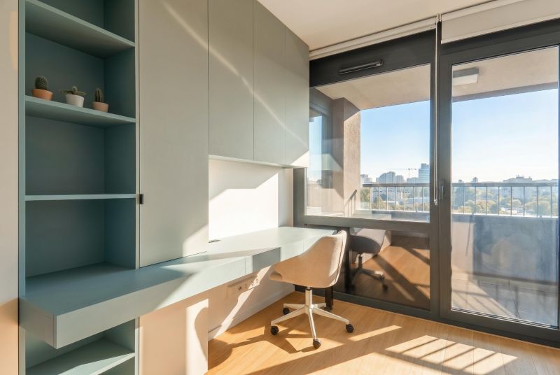Workspace in a 3-room apartment with wood-patterned flooring and a view of the city.