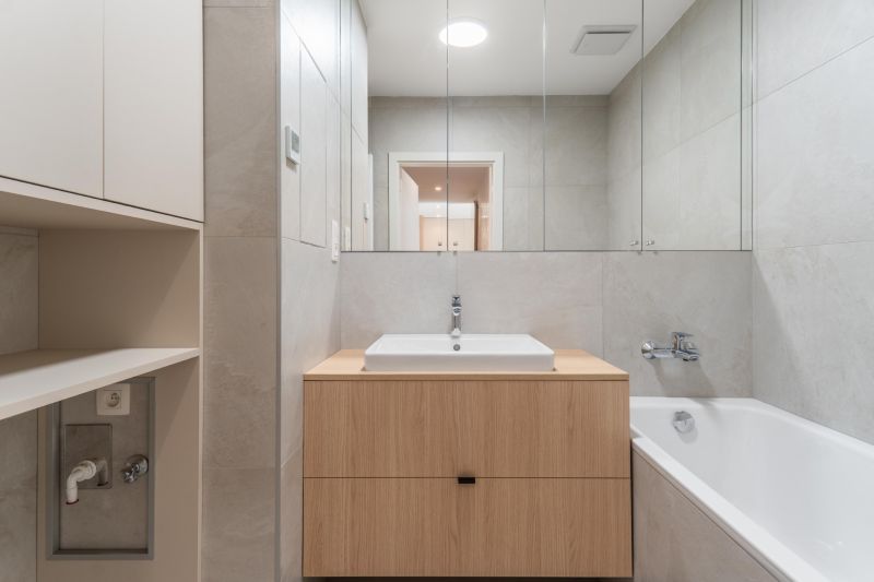A bathroom with a mirror and a sink on a wooden cabinet in a 3-room apartment.