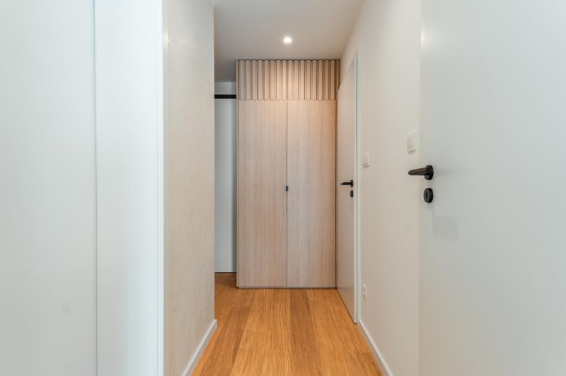 A hallway in a 3-room apartment with a wooden decor floor and a built-in wardrobe.