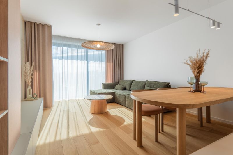Living room in a 3-room apartment with a comfortable couch and wooden decor flooring.