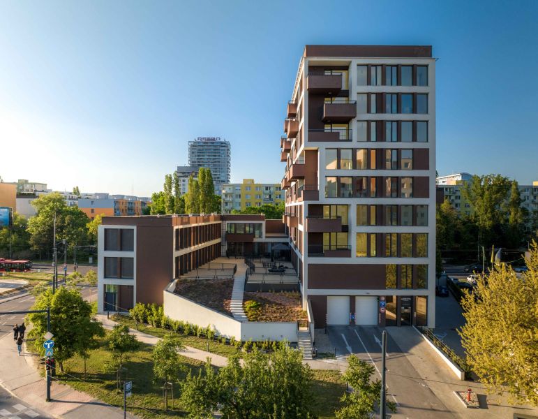 The building with large windows and greenery is located on Mierová Street in Bratislava.