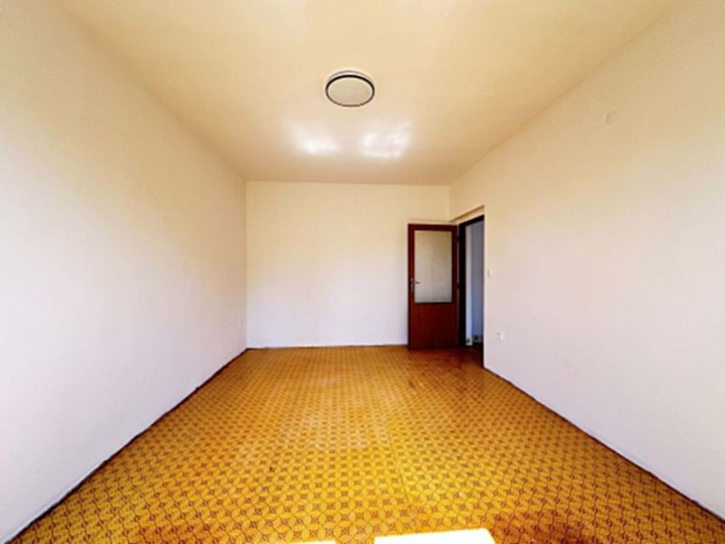 The interior of a room in a family house with a yellow decor floor and white walls.