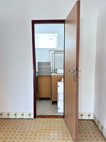 Opening door leading to a bathroom with tiled floor in a family house.