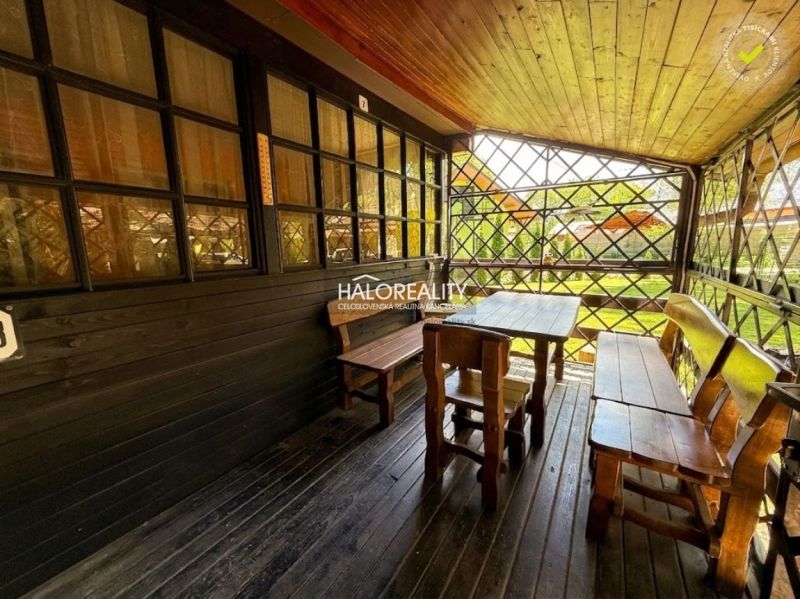 The terrace of the cottage in Prašice with wooden seating and a view of the garden.