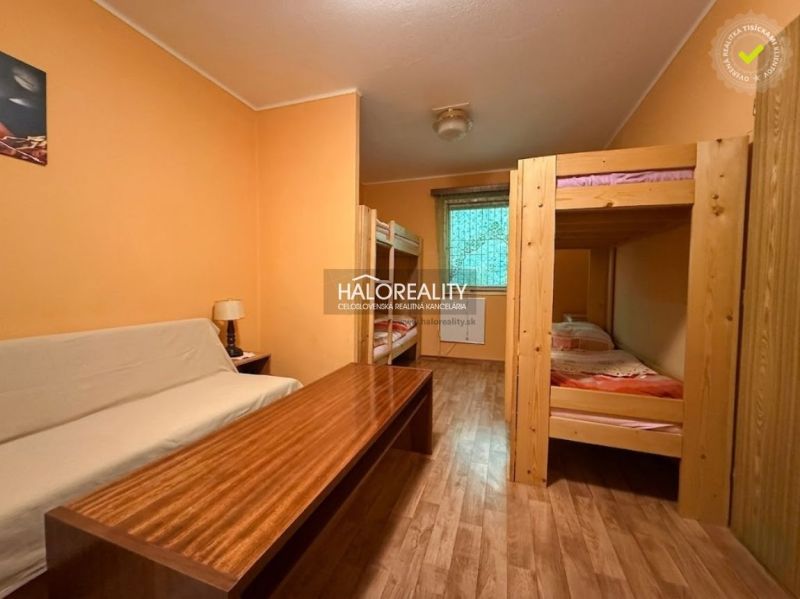 A room in a cabin with bunk beds and a wooden decor floor.
