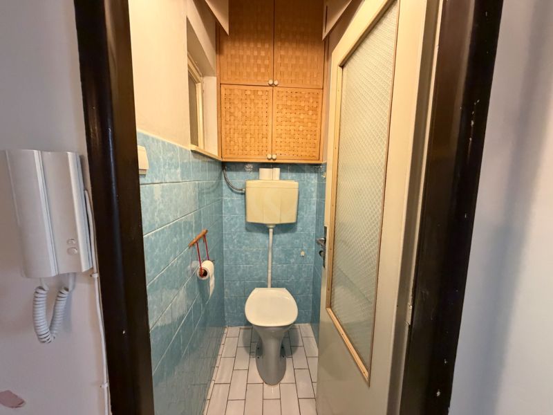 Bathroom in a 3-room apartment with blue tiles and a toilet.