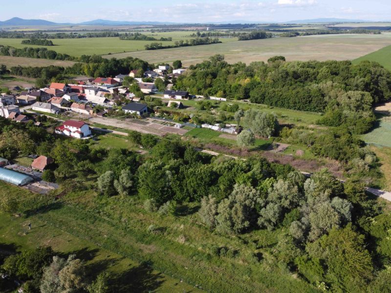 Aerial view of picturesque gardens and landscape in Branč with mountains in the background.
