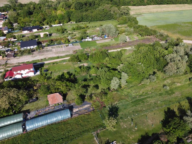 An aerial view of green gardens in Branč with plots and houses.