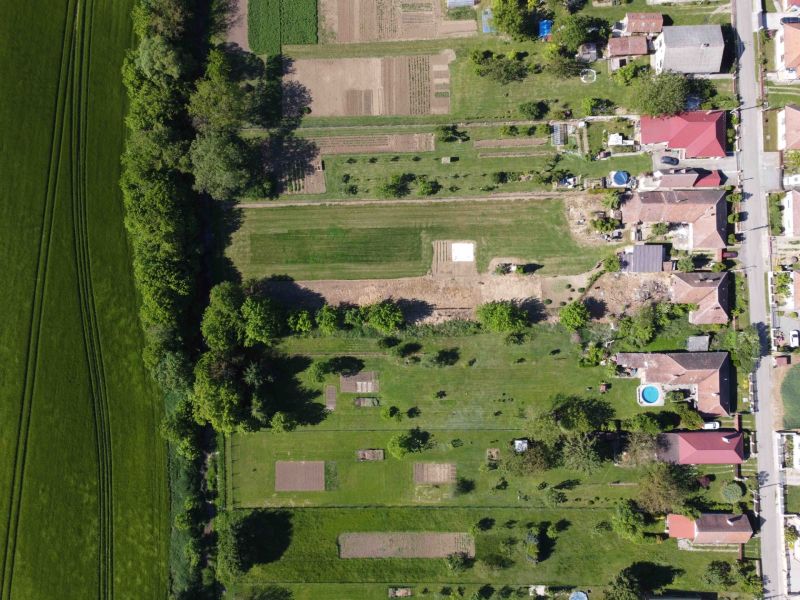 Aerial view of gardens and fields in Hruboňovo surrounded by greenery.