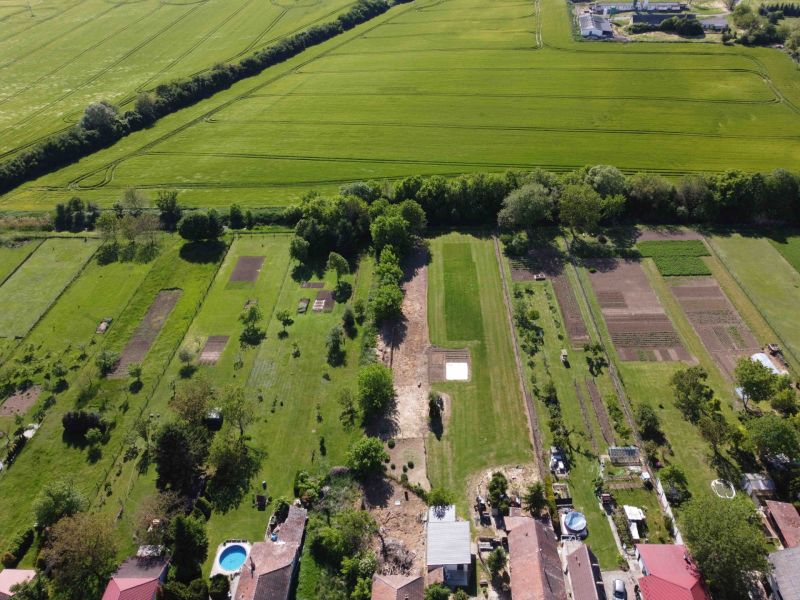 An aerial view of the gardens in Hruboňovo, surrounded by green fields and trees.