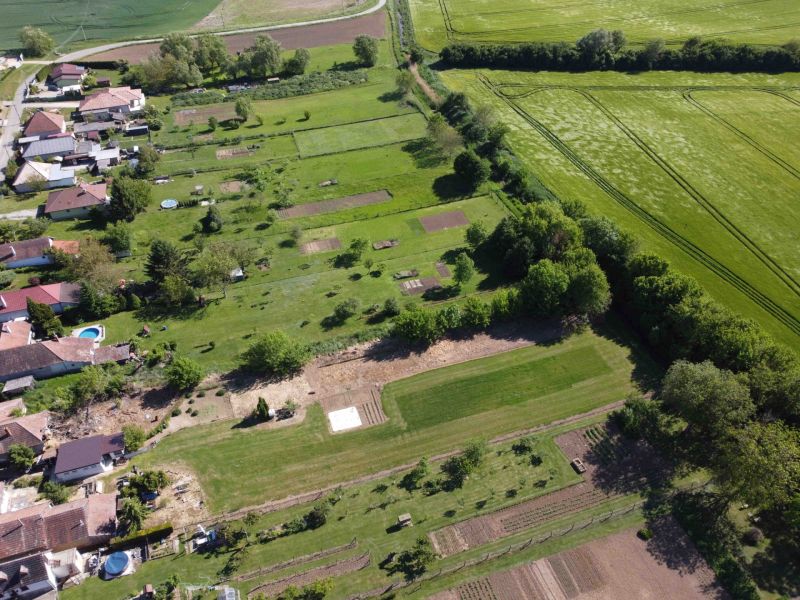 Aerial view of gardens in Hruboňovo, surrounded by fields and rural landscape.